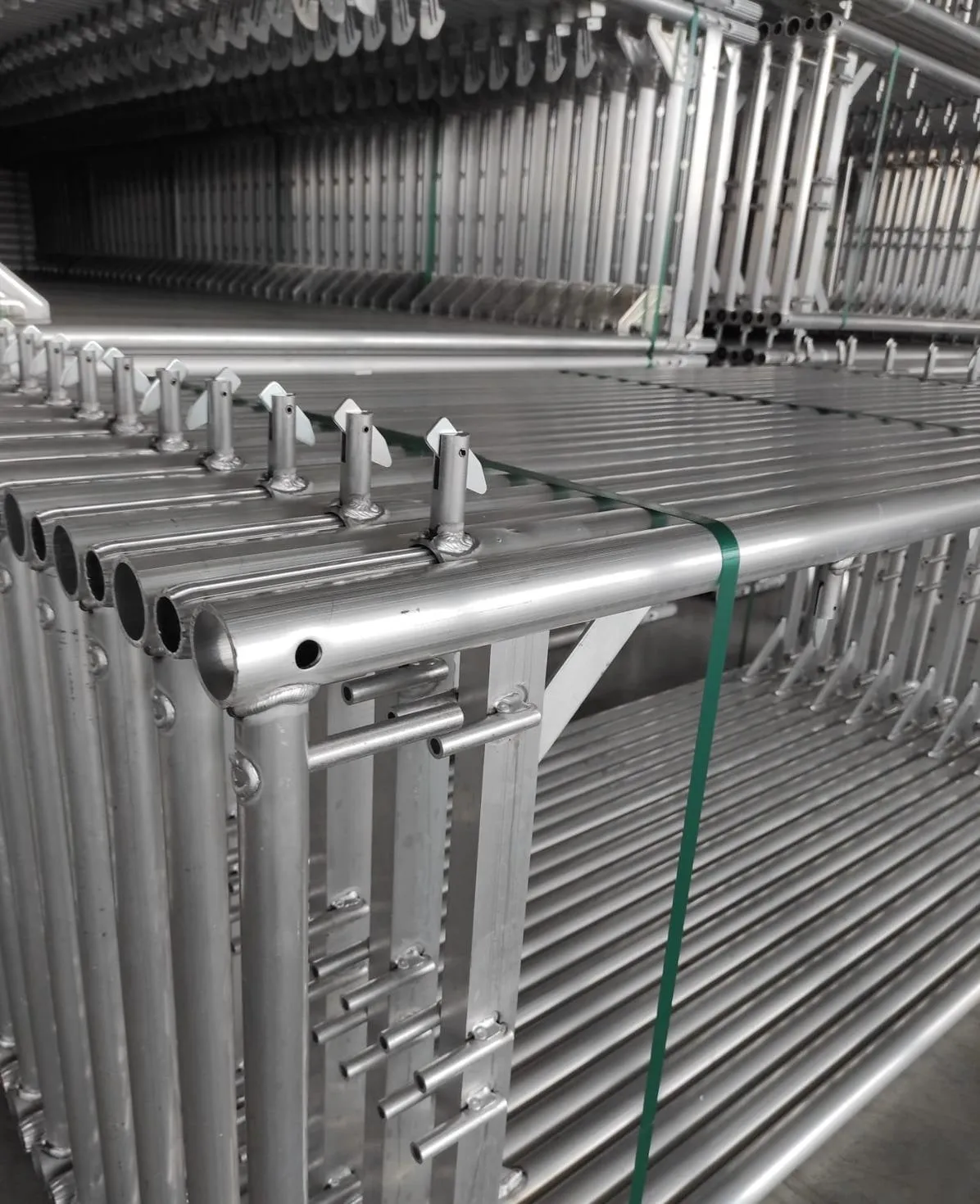 Cadres d'échafaudage en aluminium stockés par dizaines dans un entrepôt