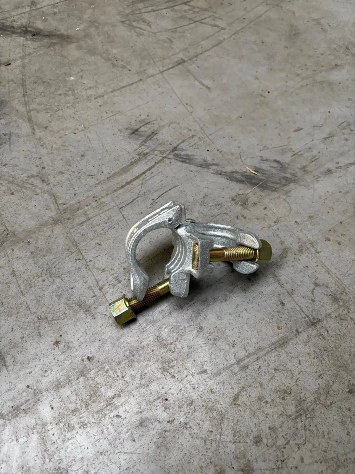 Collier orientable d'échafaudage en acier galvanisé posé sur un sol béton