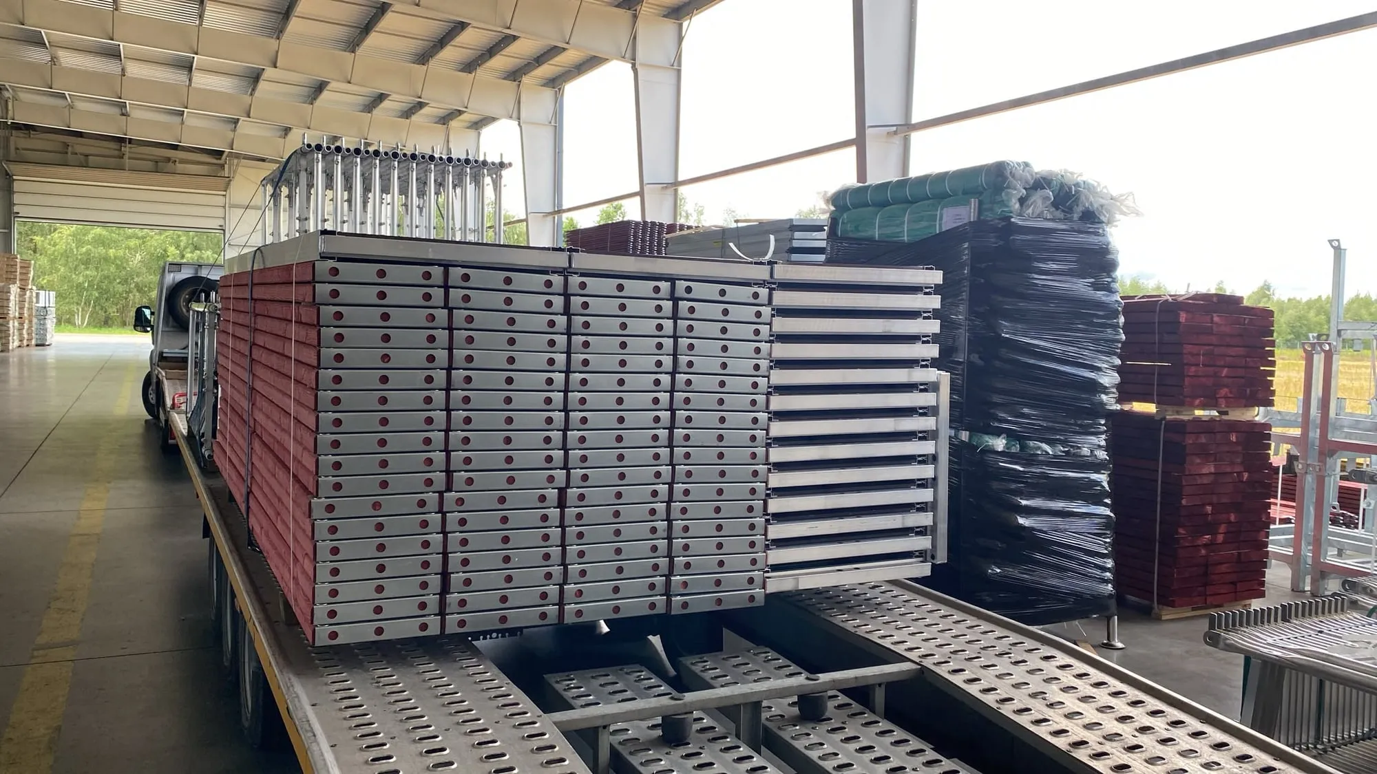 Planchers d'échafaudage en aluminium sanglés sur un plateau sous un hangar de stockage
